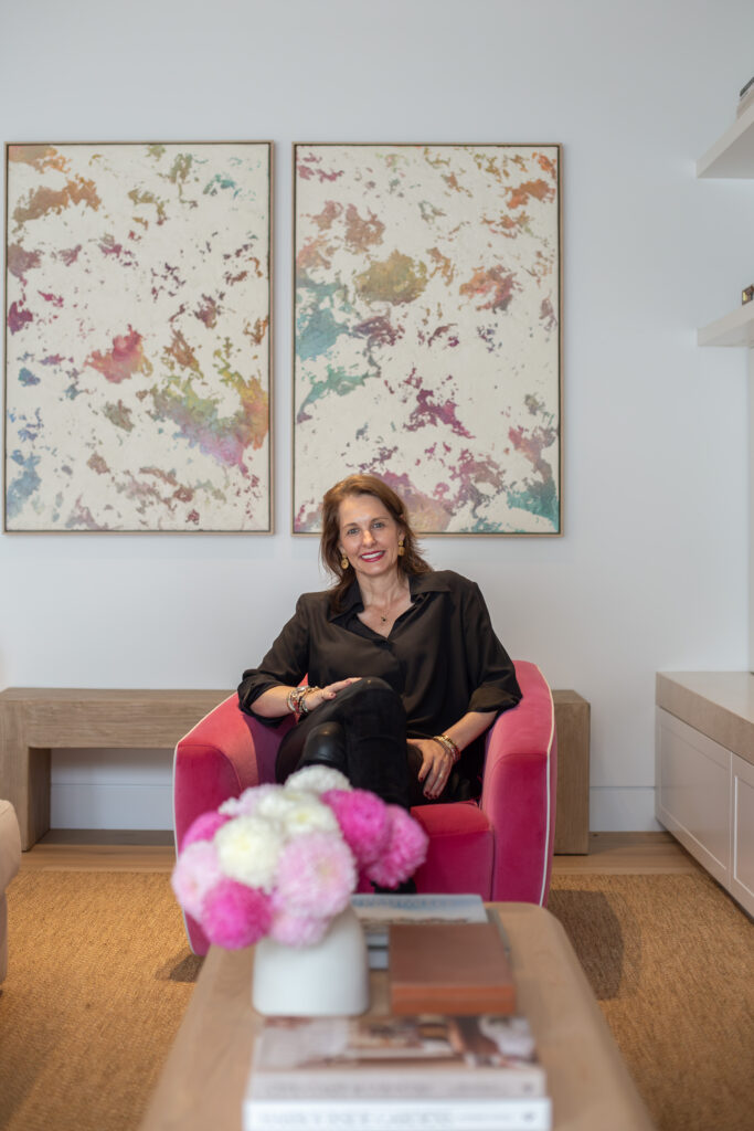 Amy seated beneath a pair of large abstract paintings in the living room
